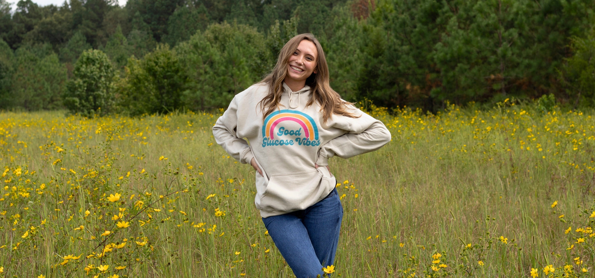 Girl standing in field wearing a Good Glucose vibes sweatshrt.