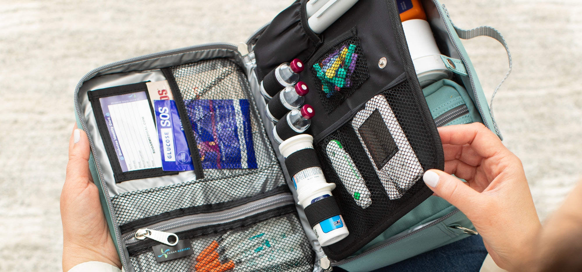 An opened seafoam Diabetes Insulted Travel Bag organized with diabetic supplies showing all the different compartments.