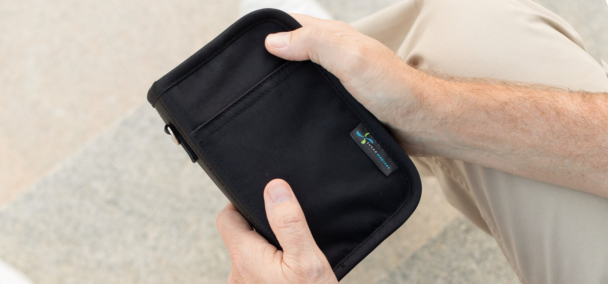 Man holding a black Diabetes Supply case in his left hand.