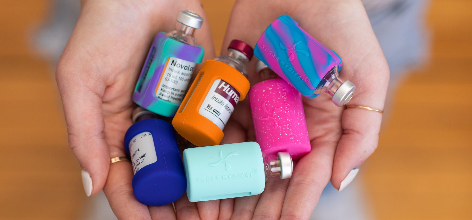 Hands hold six Insulin Vials with Protective Silicone Sleeve on them to ensure the safety of your insulin vials from bumps and drops.