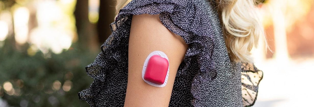 A women with black and white top wearing a red PumppPOP on her arm giving her Omnipod® a POP of color.