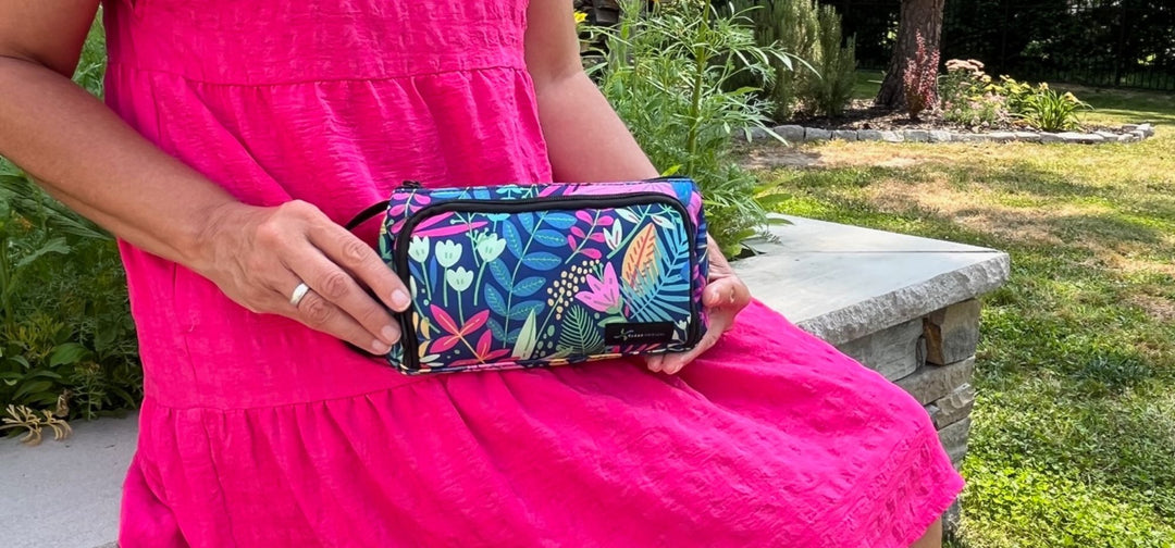 Women in pink dress sitting holding a blue floral Insulated Insulin Pen Case on her lap.
