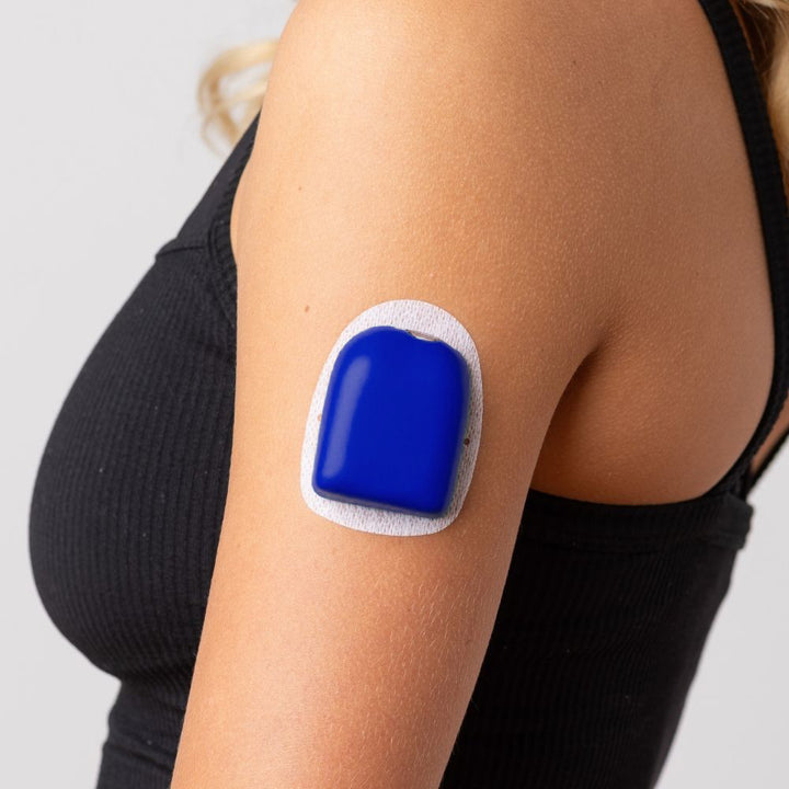 A close-up picture of a woman wearing the blue PumpPOP on the outside of her upper left arm