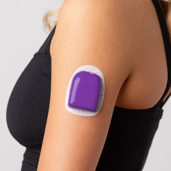 A close-up picture of a woman wearing the purple PumpPOP on the outside of her upper left arm