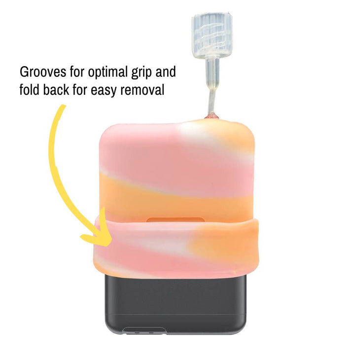 The white, pink and orange sorbet colored Mobi Tandem Gel Skin pulled up on the insulin pump showing grooves for optimal grip and fold back for easy removal.