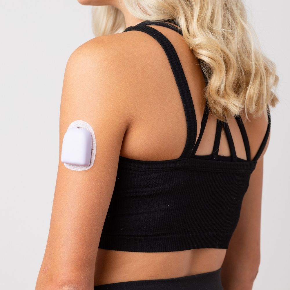 A woman wearing a lavender PumpPOP on the outside of her upper left arm