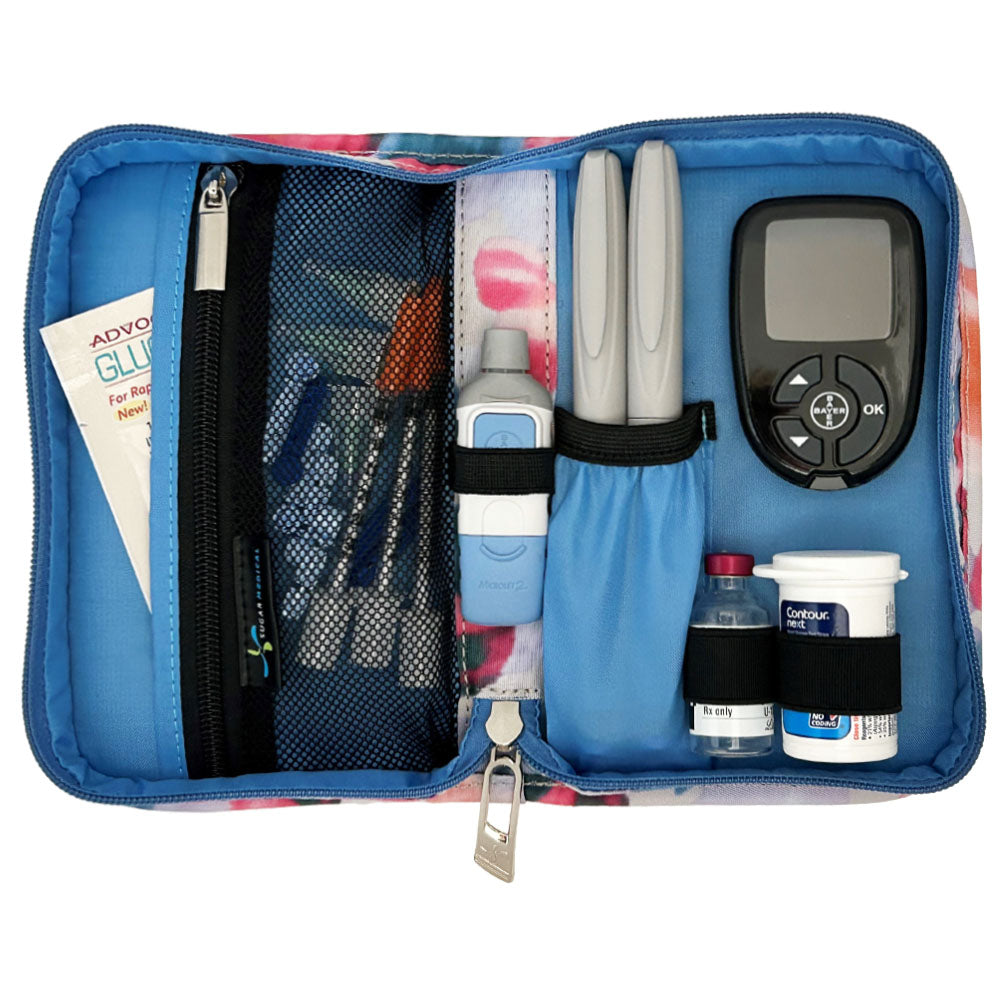 Sugar Medical Diabetes Supply Case II cream with blue, purple, and pink dots inside set up with glucose meter, test strips, lancet, insulin pens and glucose sos. 