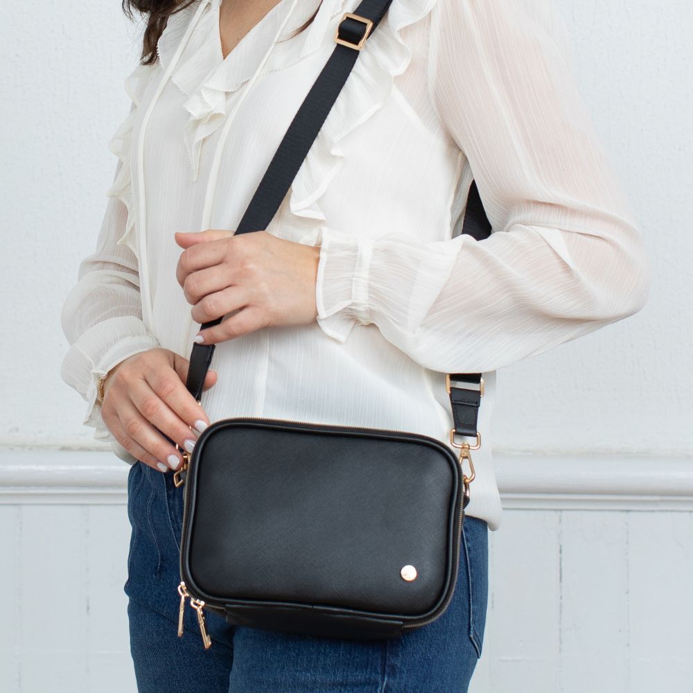 Woman wearing the Black Essential Diabetes Purse on her shoulder, highlighting its stylish design, slim profile, and comfortable shoulder strap.