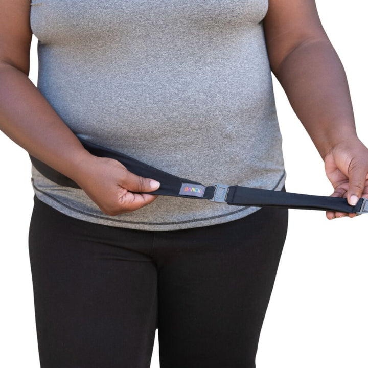 Women in grey t-shirt holding out the  the black belt extender for Bandi belt.