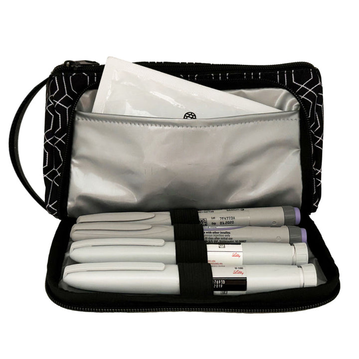 A black and white geometric pattern Insulated Diabetes Insulin Supply Case with insulated pocket open and an ice pack in slip pocket and four insulin pens secured in loops.