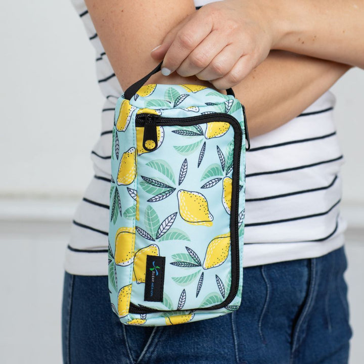 A women standing holding the lemon pattern Insulated Diabetes Insulin Supply Case by the handle.