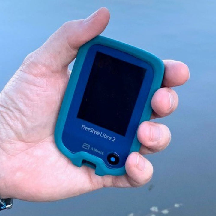 Man holding Libre device with silicone gel skin on the Libre device.