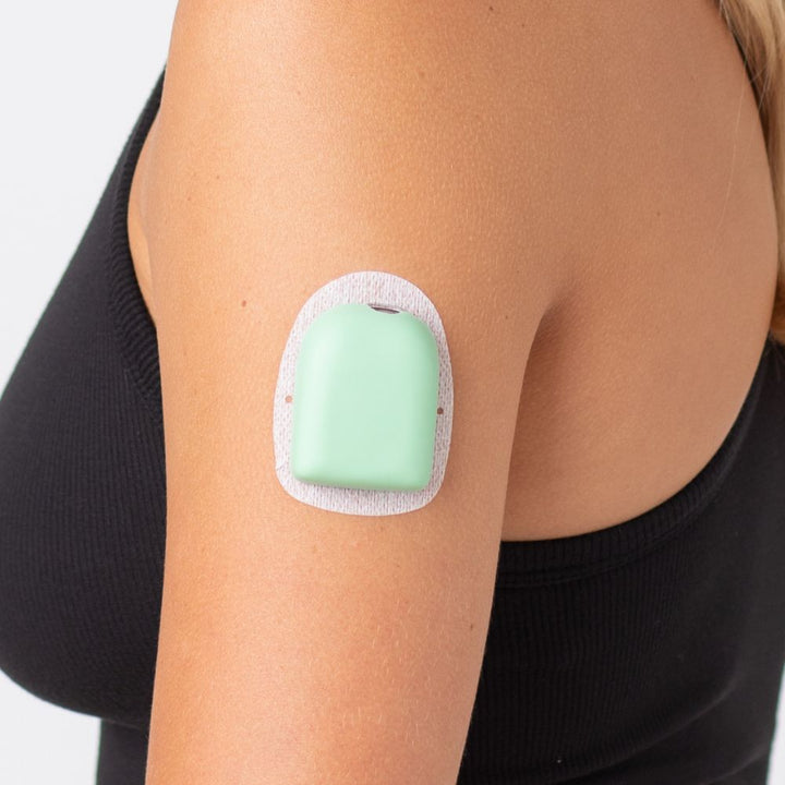 A close-up picture of a woman wearing the mint green PumpPOP on the outside of her upper left arm