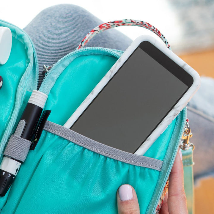 Omnipod 5 device with Sugar Medical Protective gel skin cover in a pocket of a triple zip diabetes supply case.