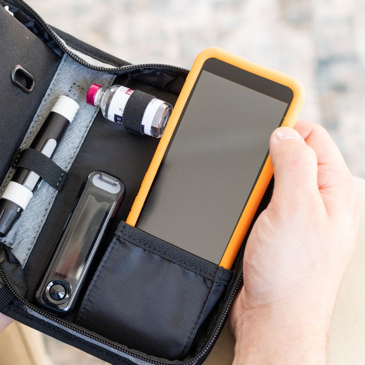 Omnipod 5 device with Sugar Medical Protective gel skin cover in a pocket of a Omnipod diabetes supply case.