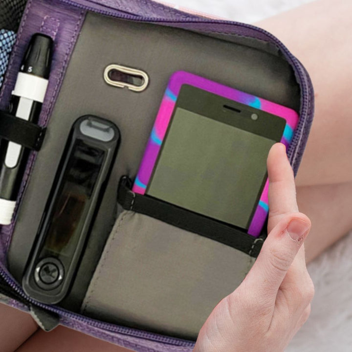 Inside of an Omnipod supply case showing a Omnipod Dash with a protective case on in the pocket.