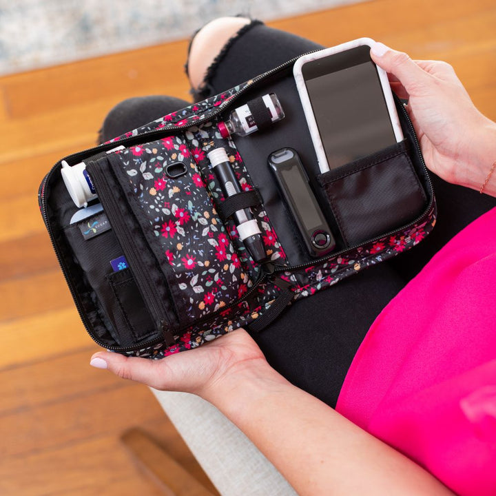 A women opening the Flora Omnipod supply case on her lap showing all the diabetic supplies organizer.