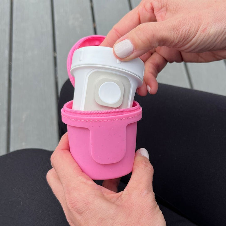 Hand pulling out Dexcom inserter out of pink glitter Dexcom G7 Protective Travel Case.