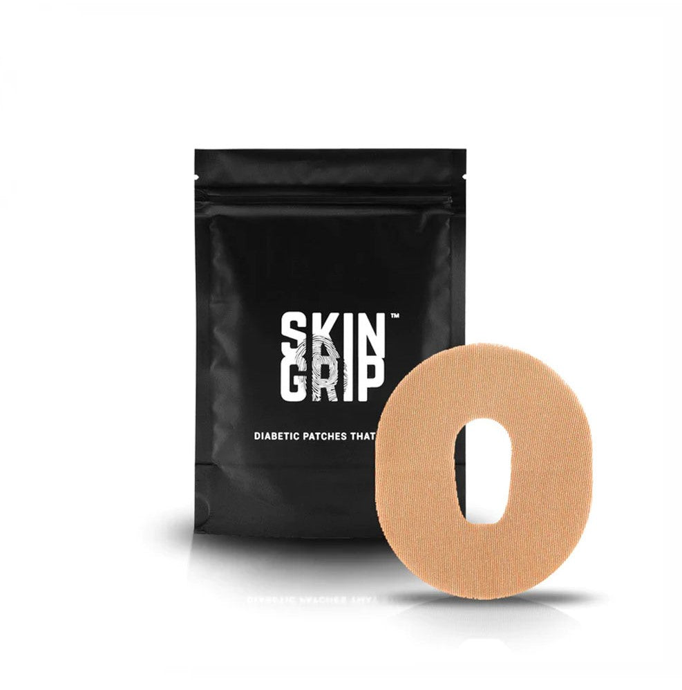 Black package that says Skin Grip which contains the adhesive patches and a tan/light brown adhesive patch designed to go around the Dexcom G6 sensor