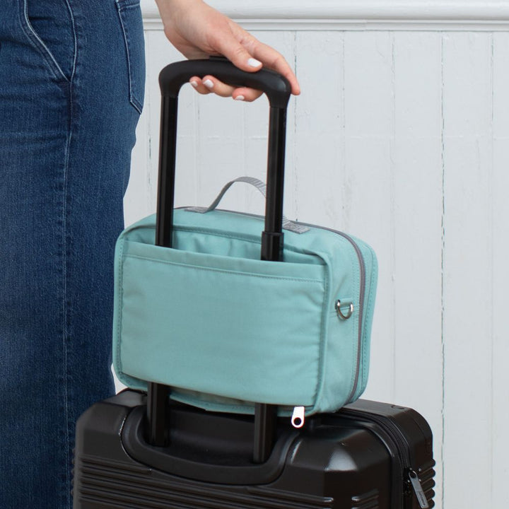 Diabetes Insulated Travel Bag in seafoam carried on a suitcase and being held by the handle.