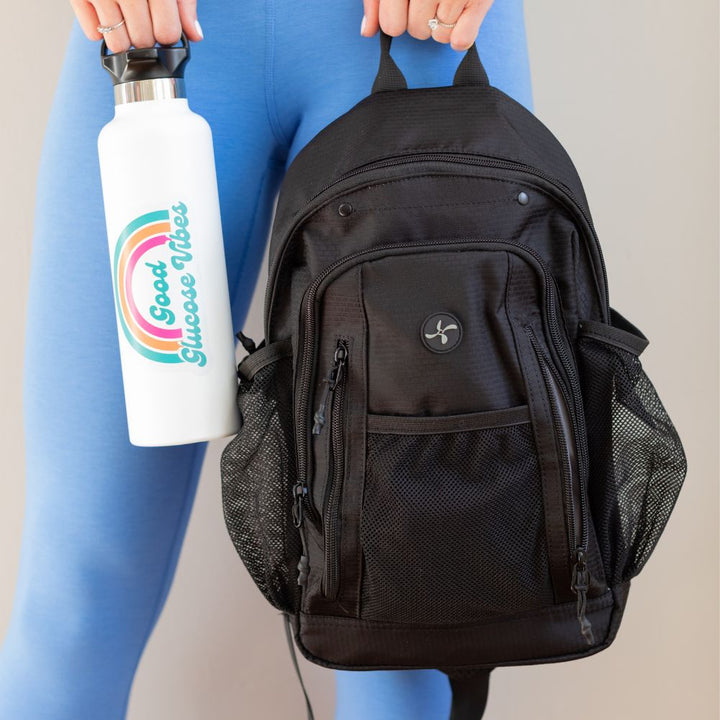 Women model holding Diabetes Insulated Sling Backpack in black by top handle.