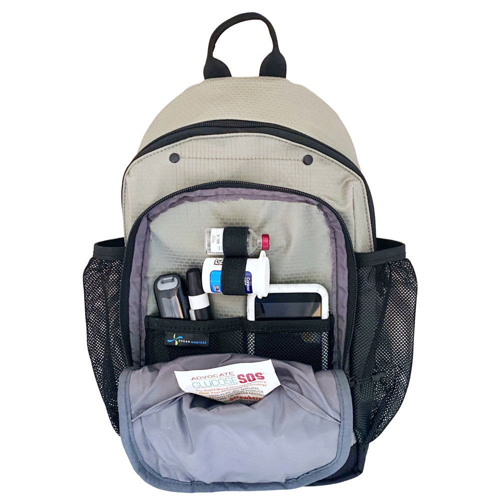 Diabetes Insulated Sling Backpack in grey front compartment set up with Omnipod 5 PDM, glucose meter, test strips, glucose SOS and lancet. 