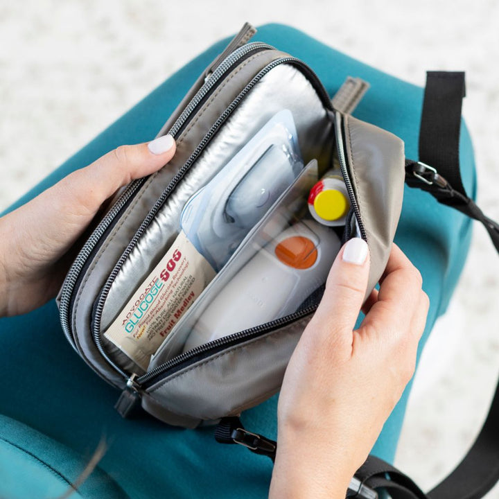 Tan Diabetes Nylon Belt Bag worn on cross body on women with opened back insulated pocket with Omnipod pump supplies and Dexcom in it. 