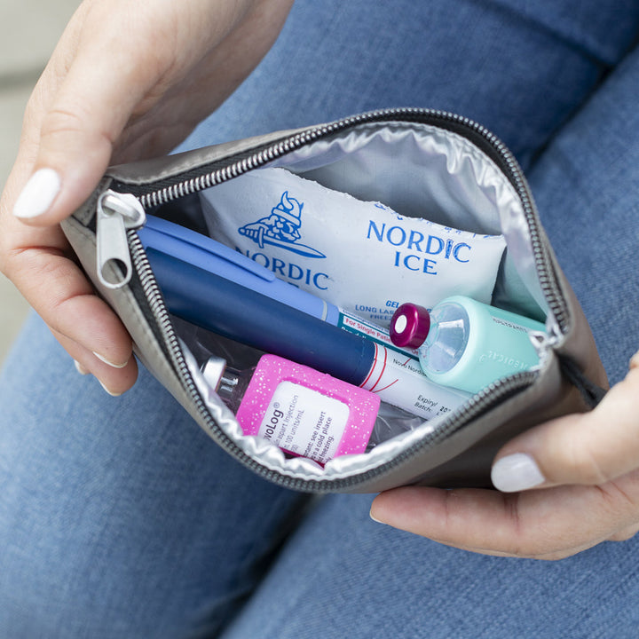 Diabetes Nylon Backpack in tan insulated pouch with ice pack, insulin pens and insulin vial opened on women’s lap.