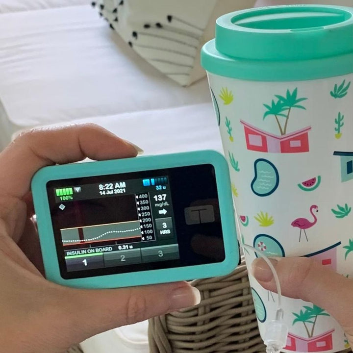 Aqua Tandem t:slim Gel Skin held in woman’s hand showing access to all ports and controls.