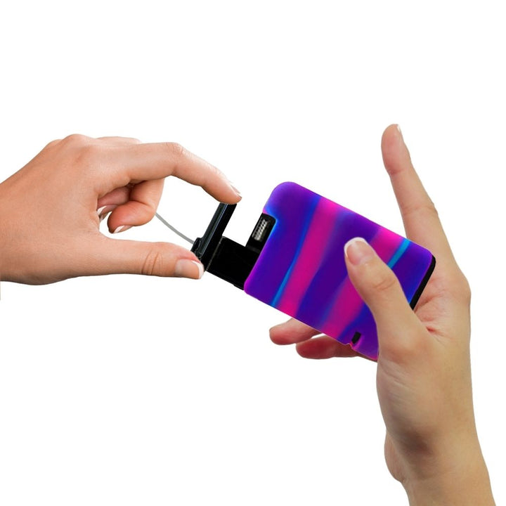 Hand pulling out Tandem cartridge with pink, purple and blue tie-dye protective silicone case on it.