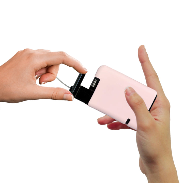 Hand pulling out Tandem cartridge with light pink protective silicone case on it.