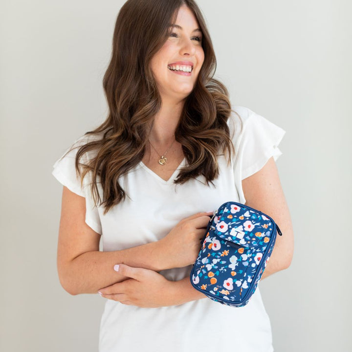 Woman in white shirt holding the Tandem Supply Case Hannah in her right hand using the side carrying strap
