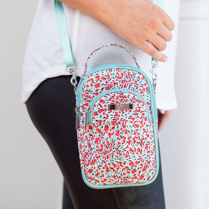 Woman standing with floral diabetes purse on her left sholder.