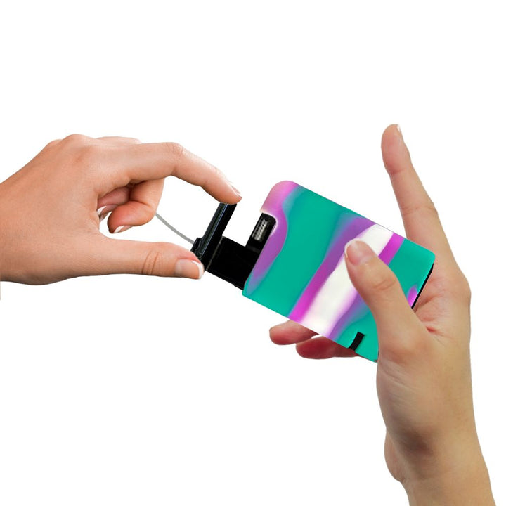 Hands pulling out a Tandem cartridge with a purple, green and white tandem gel skin on the insulin pump.