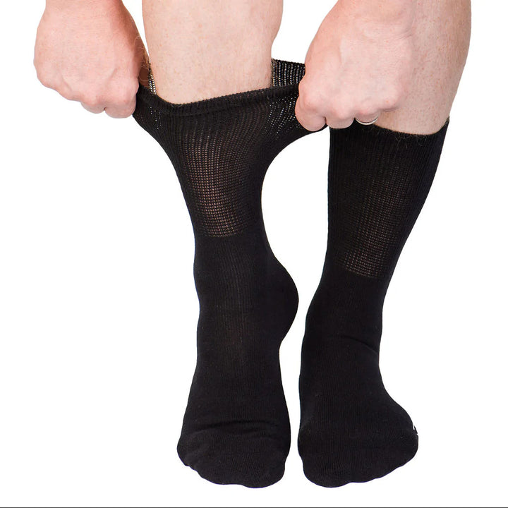 A person pulling up on their leg a pair of black Dr. Segal's Premium Diabetic Sock