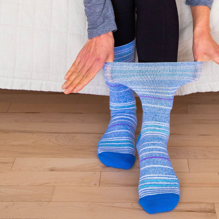 A person pulling on their foot a Blue Stripe Dr. Segal's Premium Diabetic Sock.