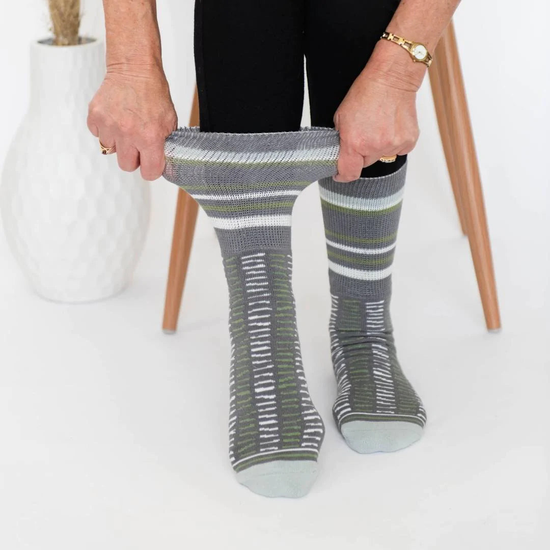 Woman wearing the Plains Grey socks and stretching the top of the sock to show it is non-binding. 