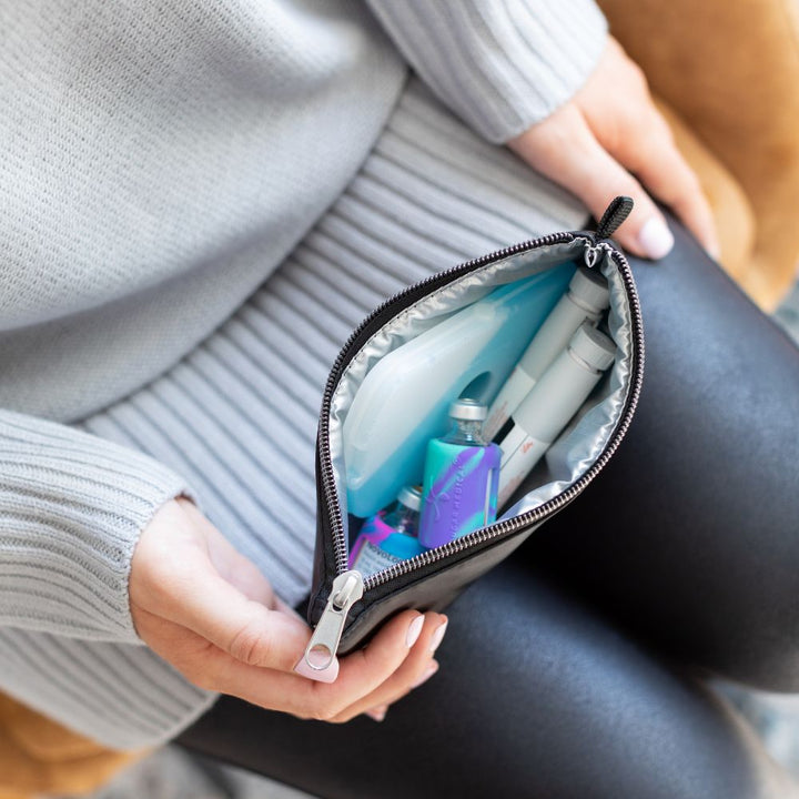 Diabetes Nylon Backpack in black insulated pouch with ice pack, insulin pens and insulin vial opened on women’s lap. 