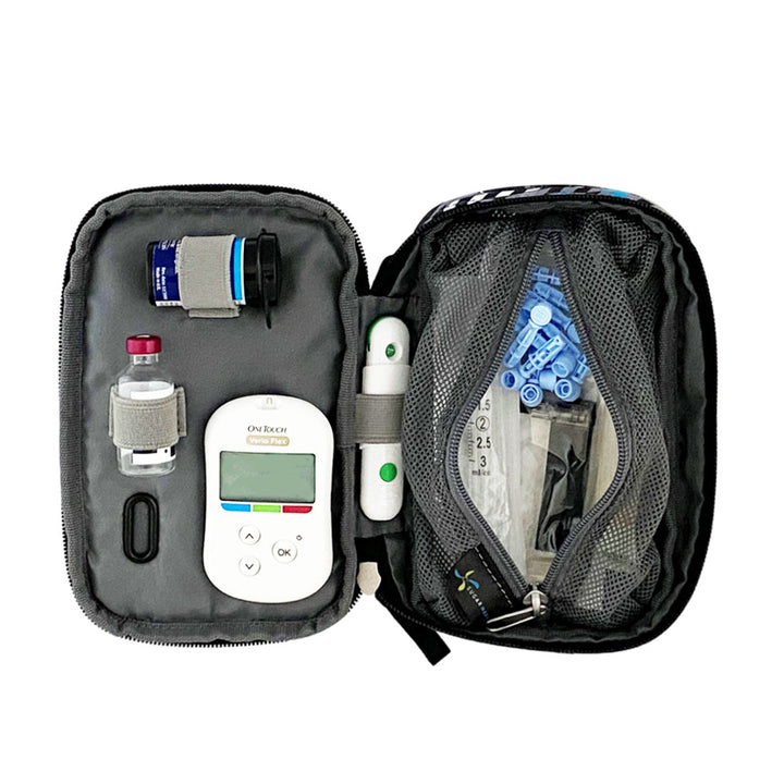 Tandem supply case in black, blue and grey opened flat with inside set up containing glucose meter, test strips, lancet, and insulin vial on the left and a large mesh pocket on the right with extra supplies.