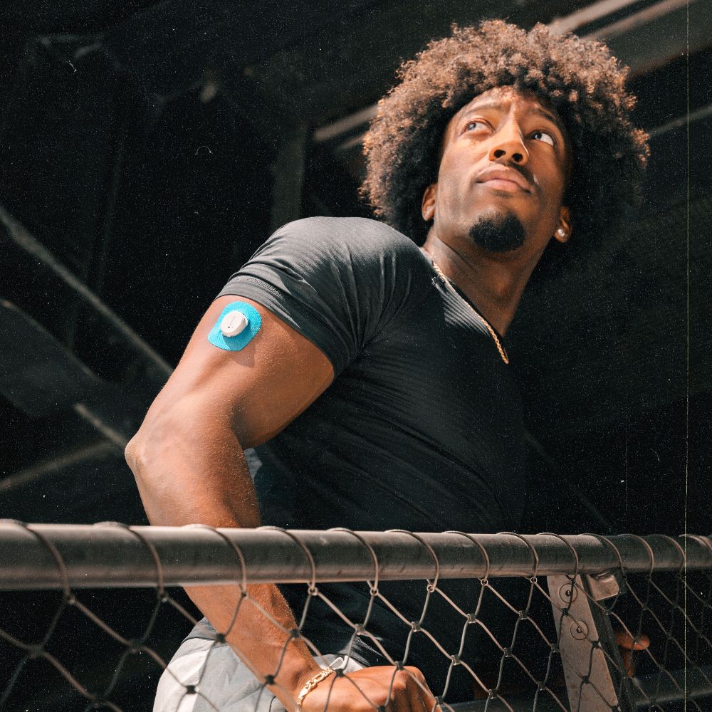 A man wearing a blue Skin Grip on his arm around Dexcom G7. 
