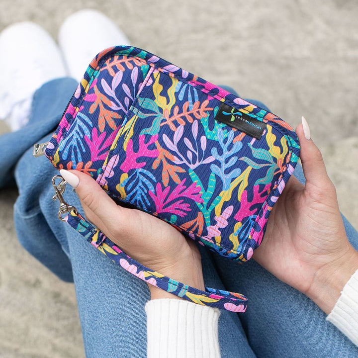 Women holding a navy with bright color diabetes supply case in her lap.