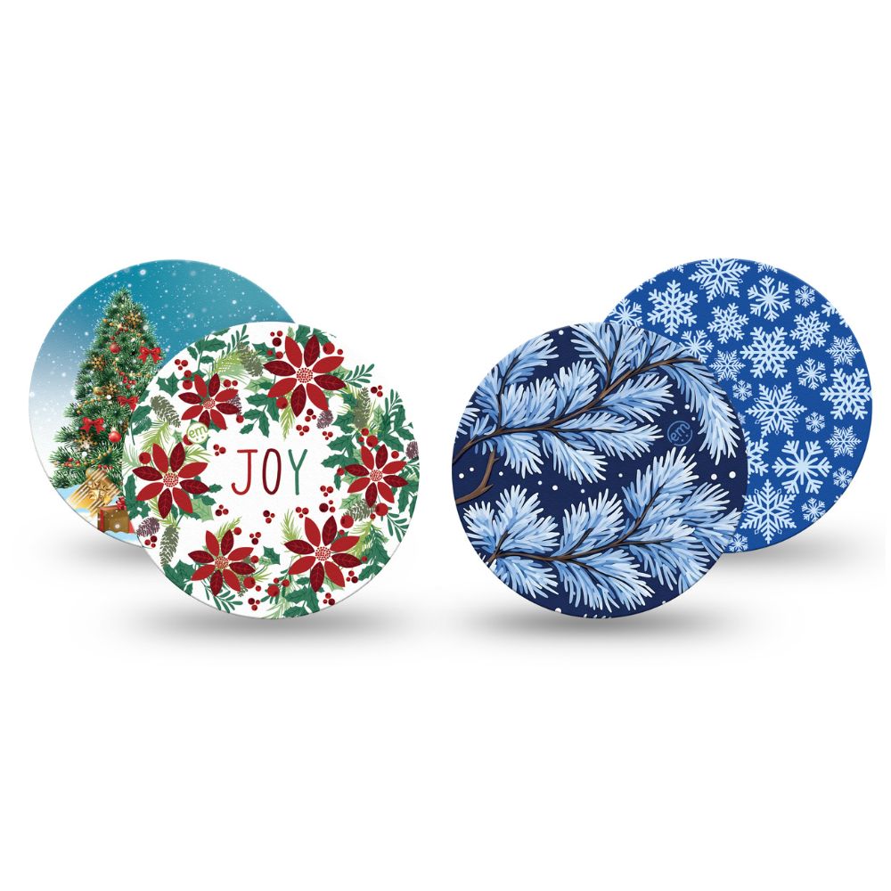 Four Expression Med libre 2 overpatches with winter and holiday designs, including a Christmas tree, red poinsettias with 'JOY' text, blue pine branches, and blue snowflakes, shown on a white background.