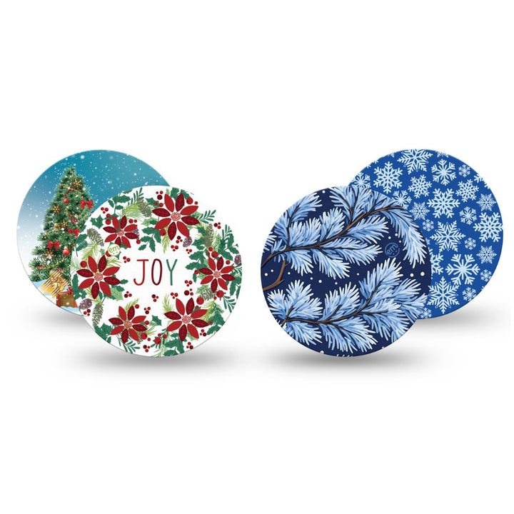 Four Expression Med libre 2 overpatches with winter and holiday designs, including a Christmas tree, red poinsettias with 'JOY' text, blue pine branches, and blue snowflakes, shown on a white background.