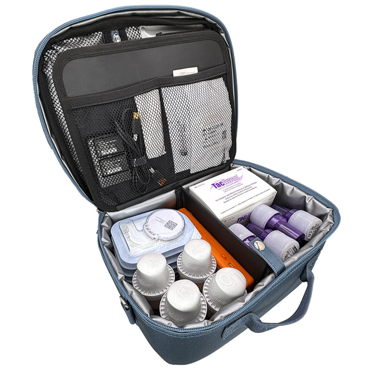 An open steel blue medical travel kit organizer bag, shown against a white background. The bag is packed with various twiist diabetes supplies and other medical items organized in mesh and foam compartments.