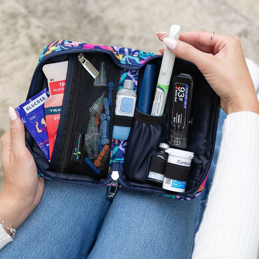 Women holding a diabetes supply case open on her lap pulling an insulin pen out. 