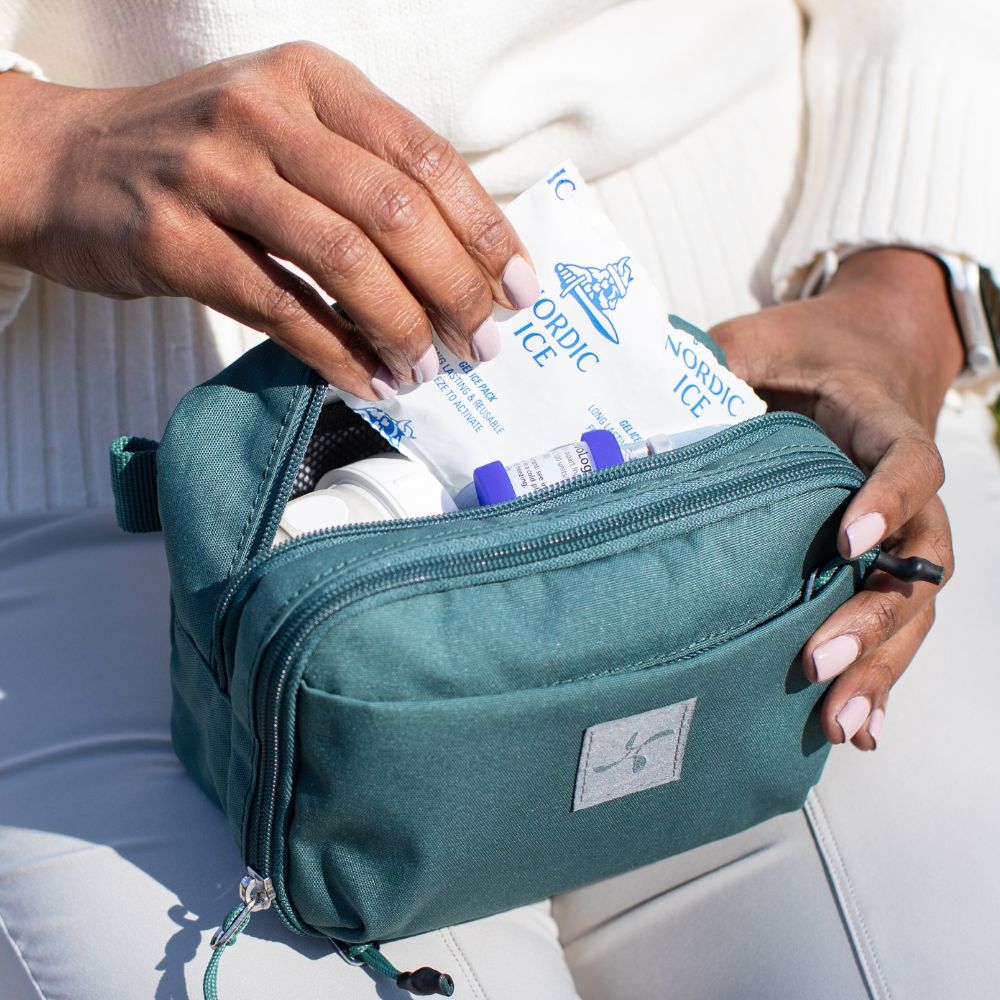 The back insulated pocket open on women lap with a woman pulling ice pack out.