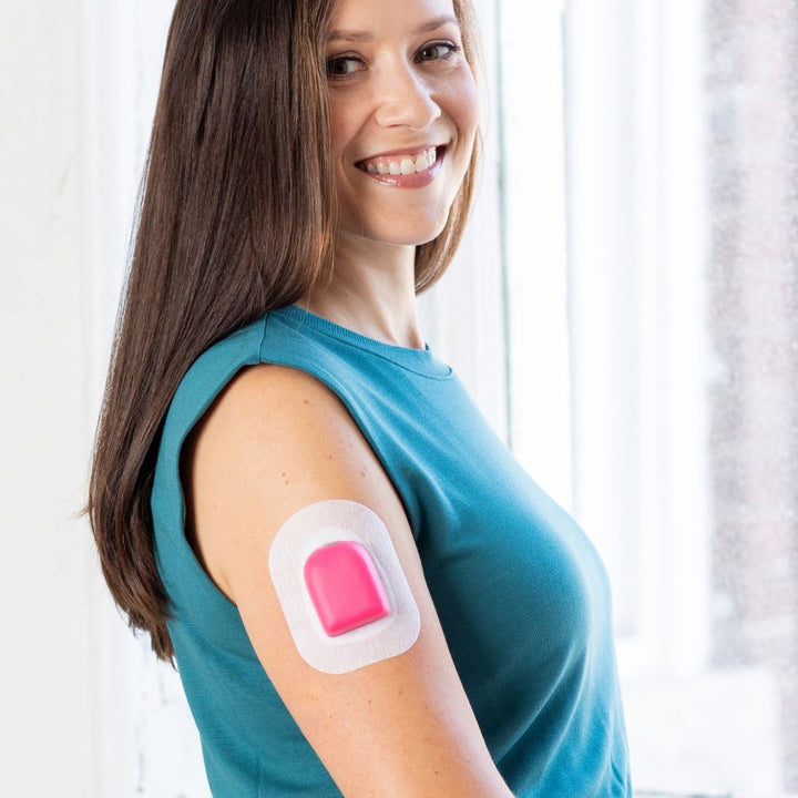 A woman wearing a raspberry PumpPOP on the outside of her upper right arm