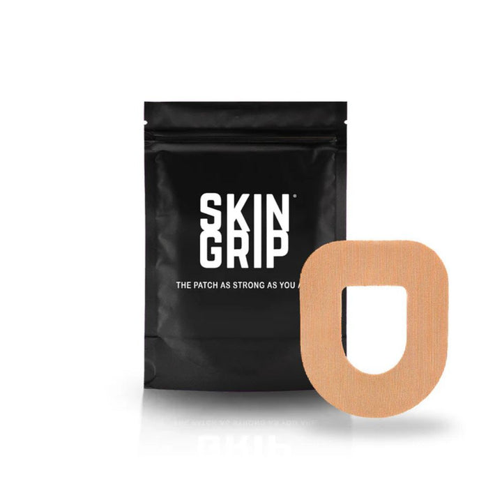 A black package that says Skin Grip containing the 20 adhesive patches and the tan Omnipod adhesive patch around a white pod