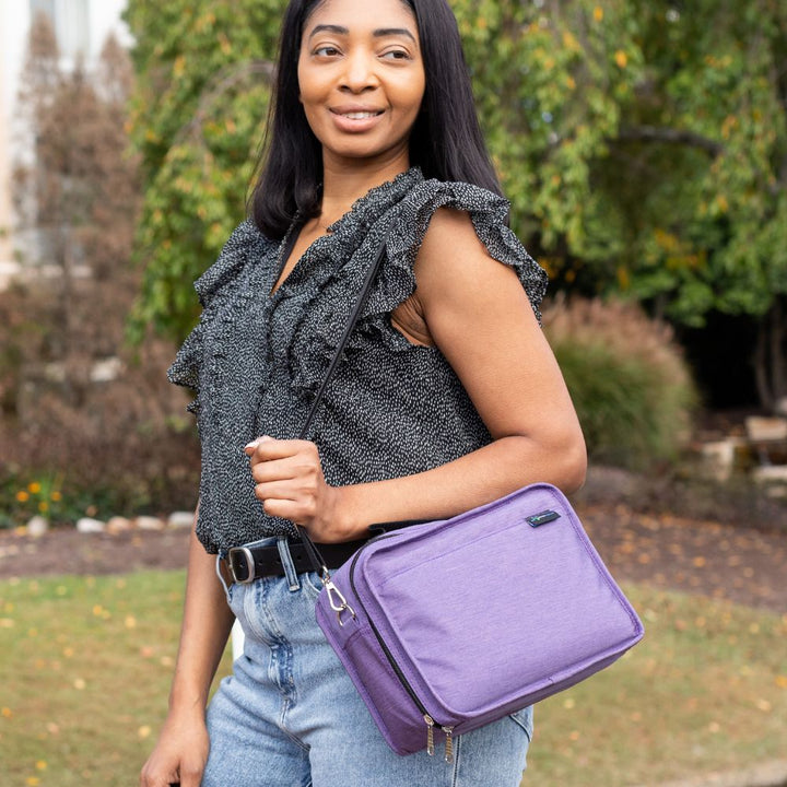 Woman wearing the purple travel bag on her shoulder, showcasing its stylish and functional design.







