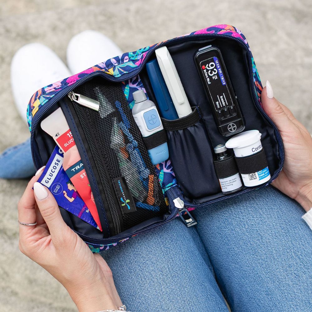 Women holding a diabetes supply case open on her lap pulling glucose out of a slip pocket. 